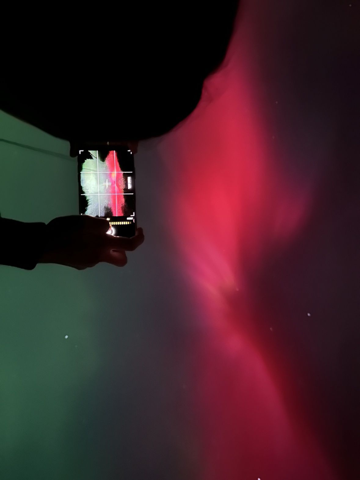 Holding a phone up to photograph the aurora